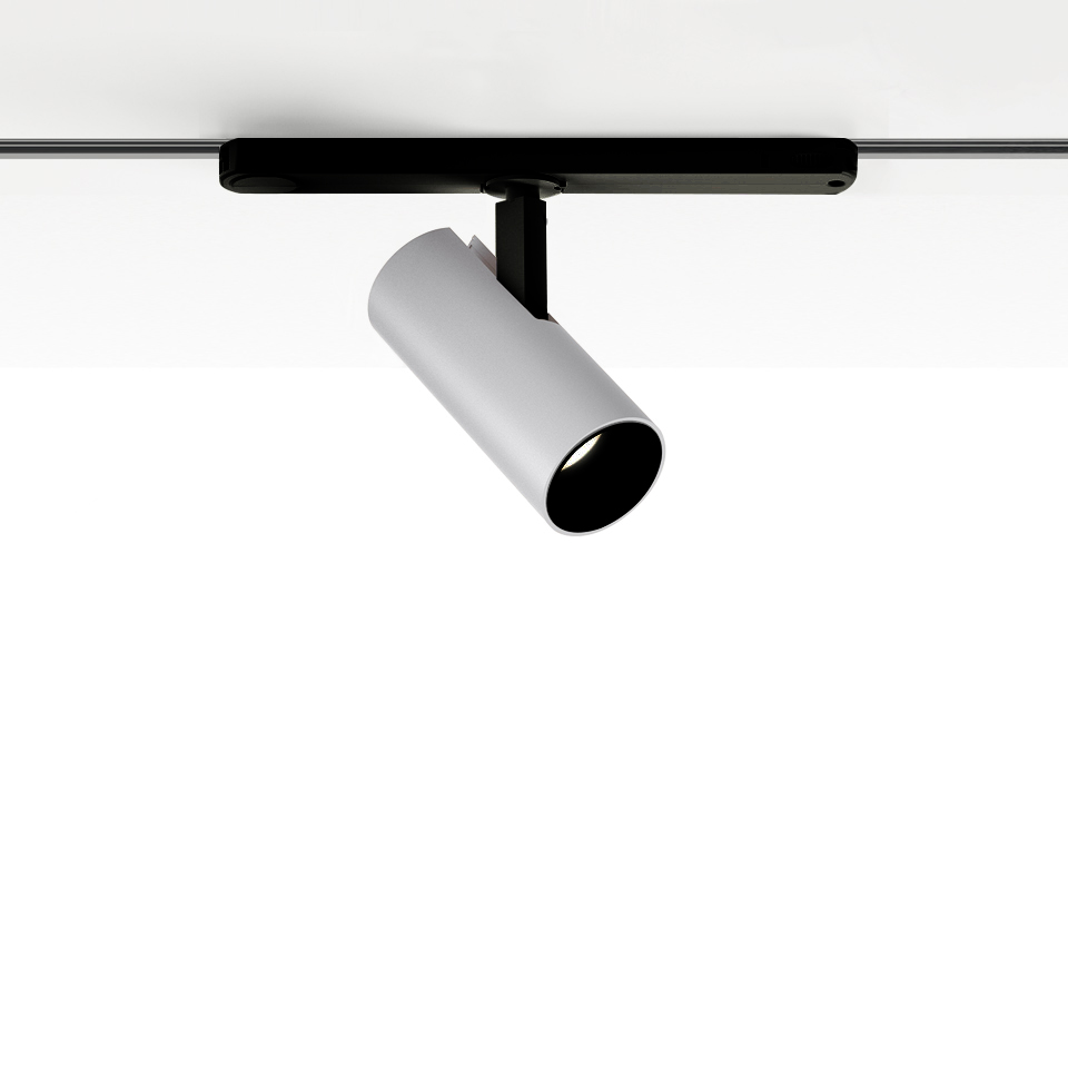 Artemide Vector Track 230V: faretto cilindrico bianco orientabile montato su binario nero, inclinato verso il basso