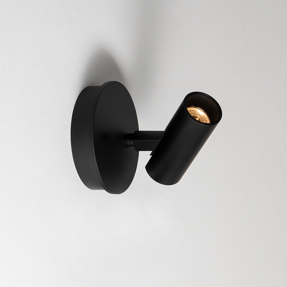 Artemide Vector Wall spotlight in black, featuring a circular base and adjustable cylindrical head with warm LED light source