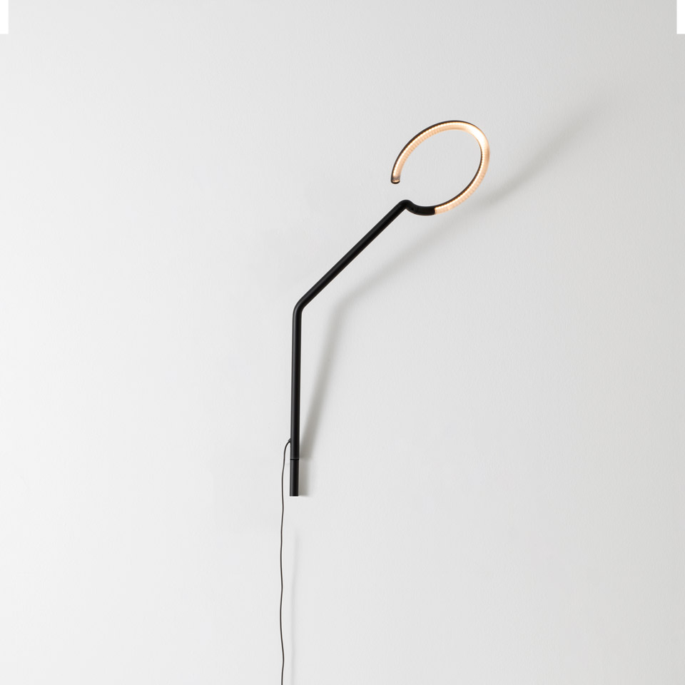 Artemide Vine Light wall lamp: black angled stem with circular LED ring diffuser in warm gold tone, minimalist design
