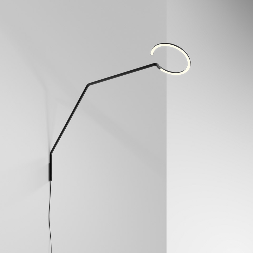 Artemide Vine Light wall lamp: slim black angled arm extending from floor, topped with a circular LED ring emitting warm white light