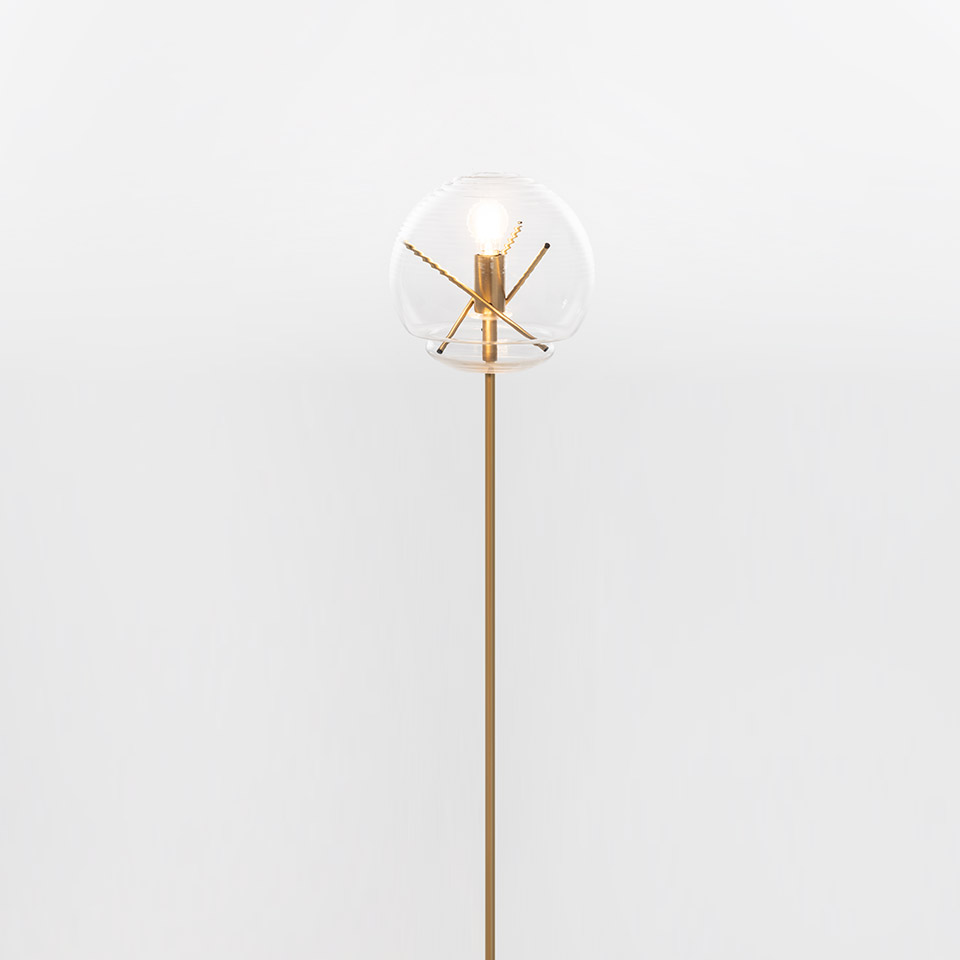 Lampada da terra Artemide Vitruvio: sottile stelo in ottone sormontato da un globo in vetro trasparente con portalampada a croce in ottone