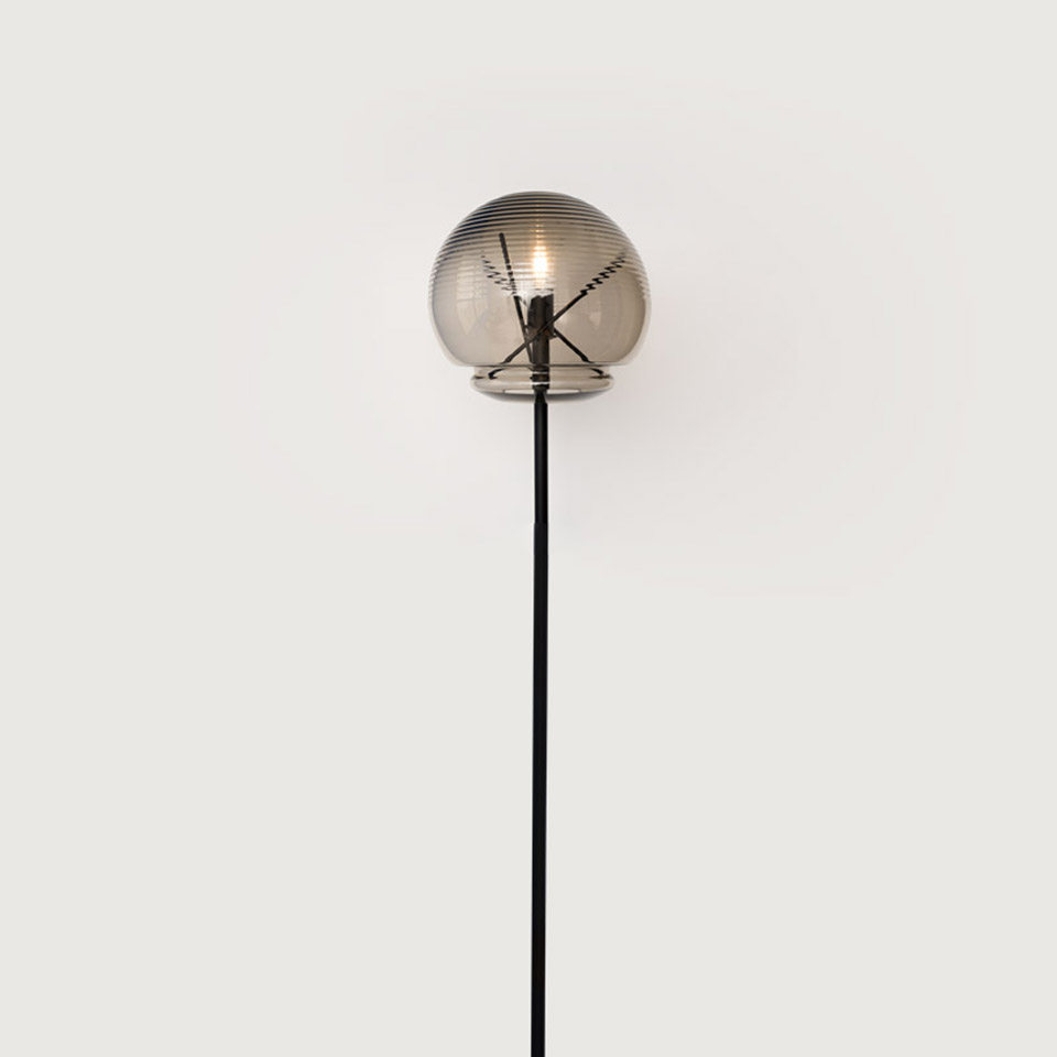 Lampada da terra Artemide Vitruvio con diffusore a globo in vetro fumé costolato su sottile stelo in metallo nero