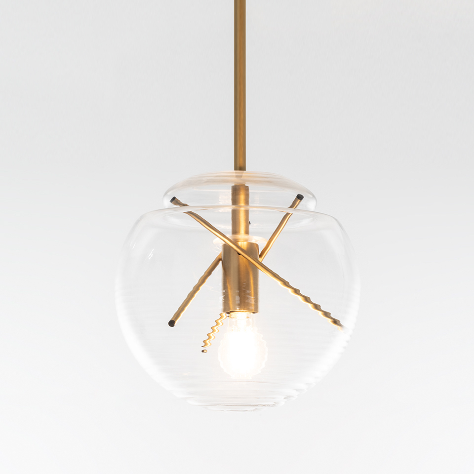 Lampada a sospensione Artemide Vitruvio: globo in vetro trasparente con asta in ottone, braccia incrociate in ottone che reggono una lampada a vista stile Edison
