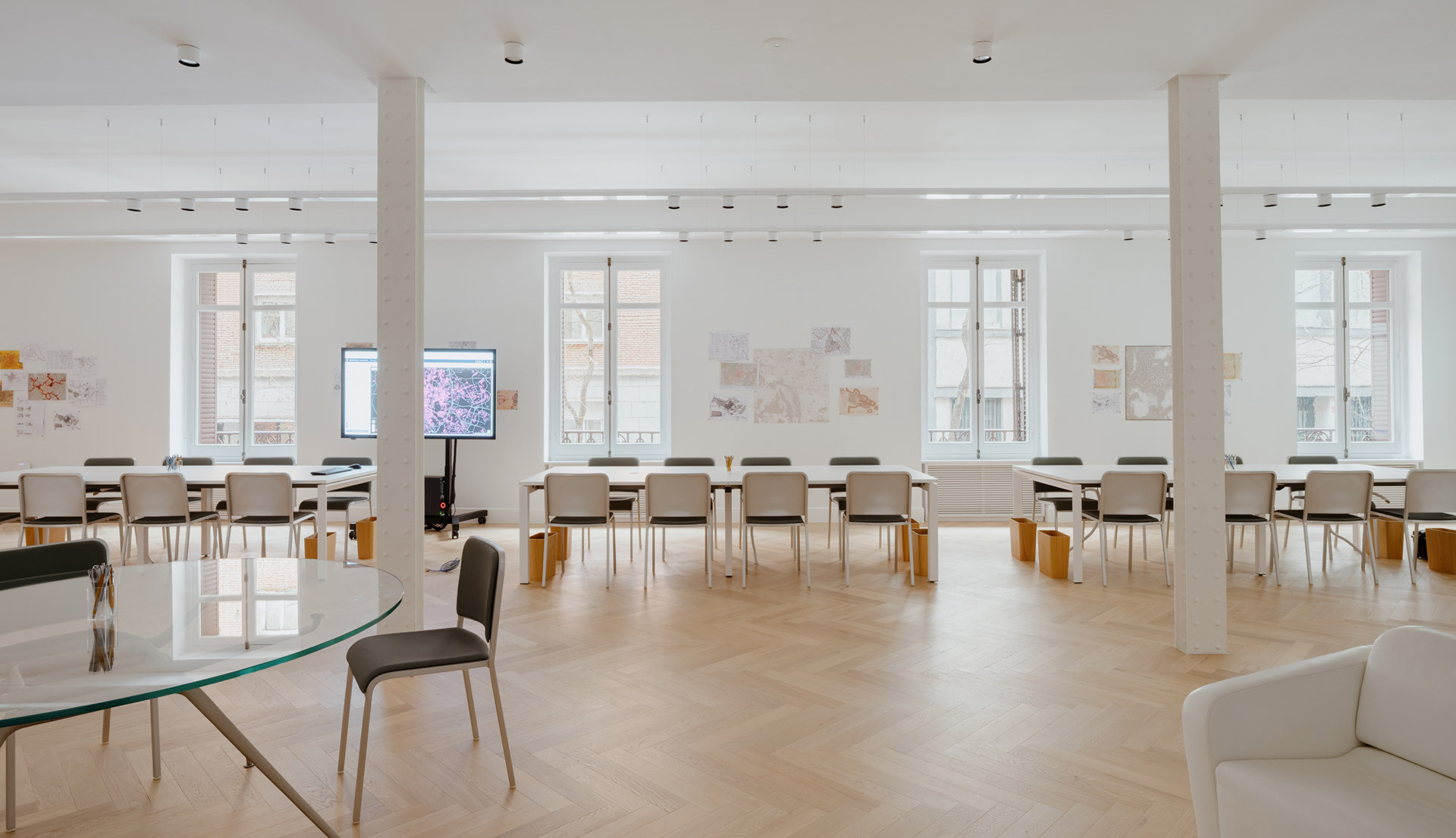 Sala riunioni con ampie finestre, tavoli e sedie, illuminata tramite i prodotti Hoy System e Hoy Spot.