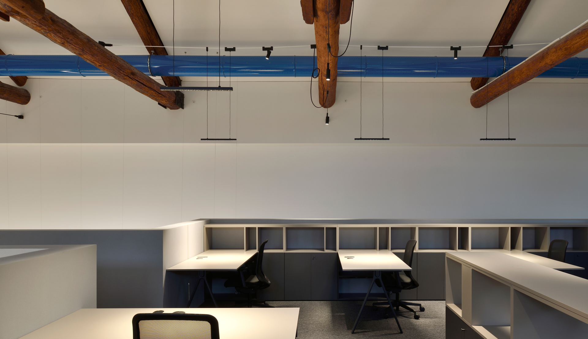 Immagine dell'ufficio con le capriate in legno illuminato con il sistema di Funivia.