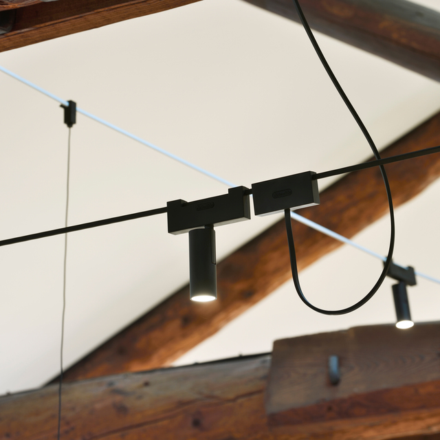 Immagine dell'ufficio con le capriate in legno illuminato con il sistema di Funivia, nel dettaglio vector.
