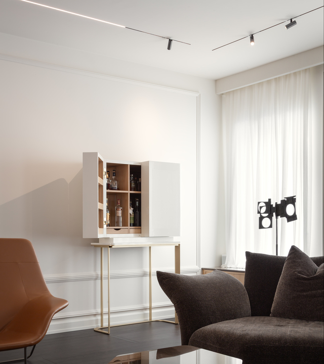 Angolo soggiorno illuminato con sistema Turn Around ad incasso, dotato di strip LED per luce diffusa e proiettori Vector 40 per un’illuminazione d’accento precisa e dinamica.