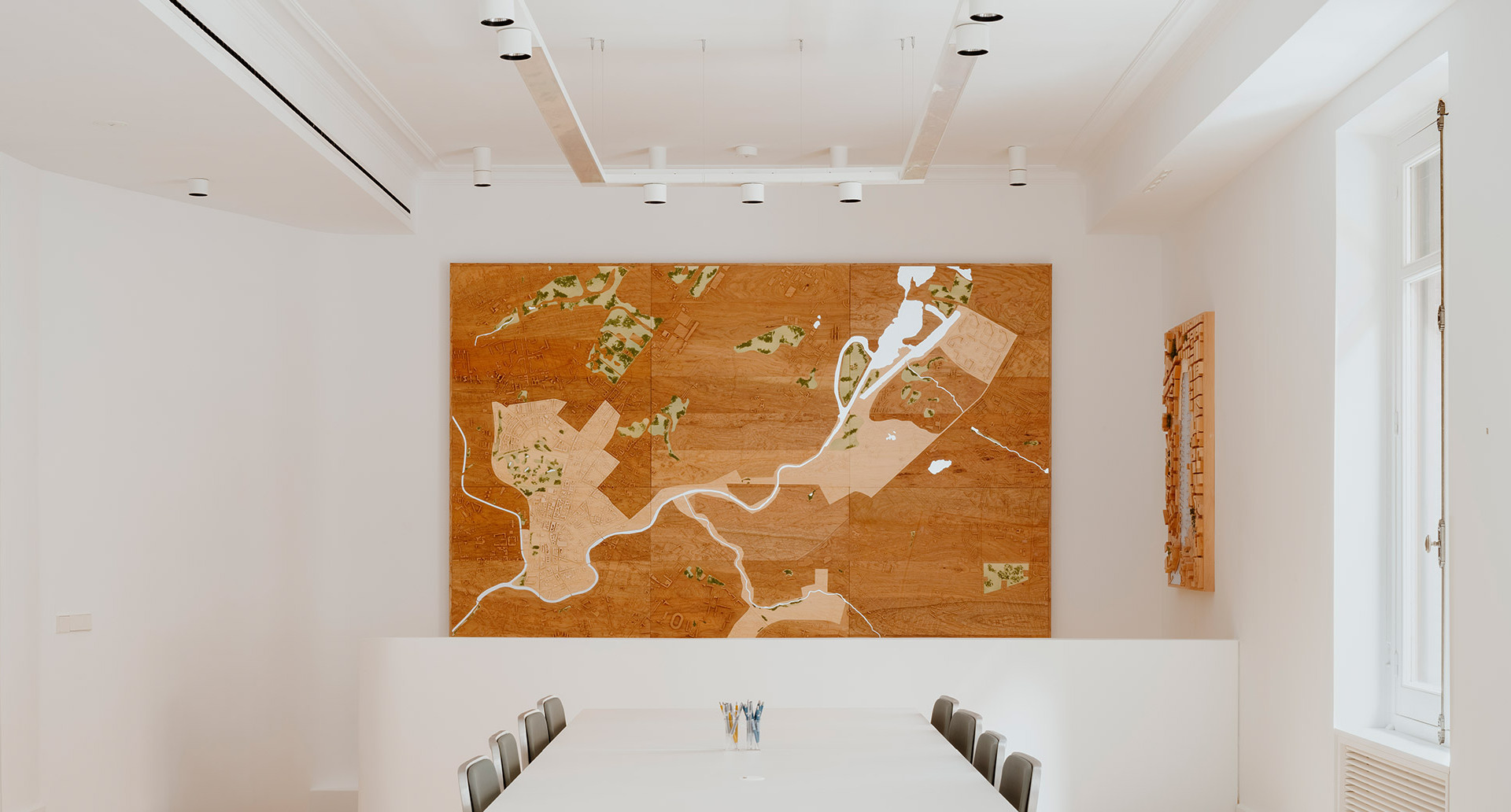 Sala della Norman Foster Foundation con tavoli, sedie e mappa murale, illuminata dai prodotti Hoy System e Hoy Spot.