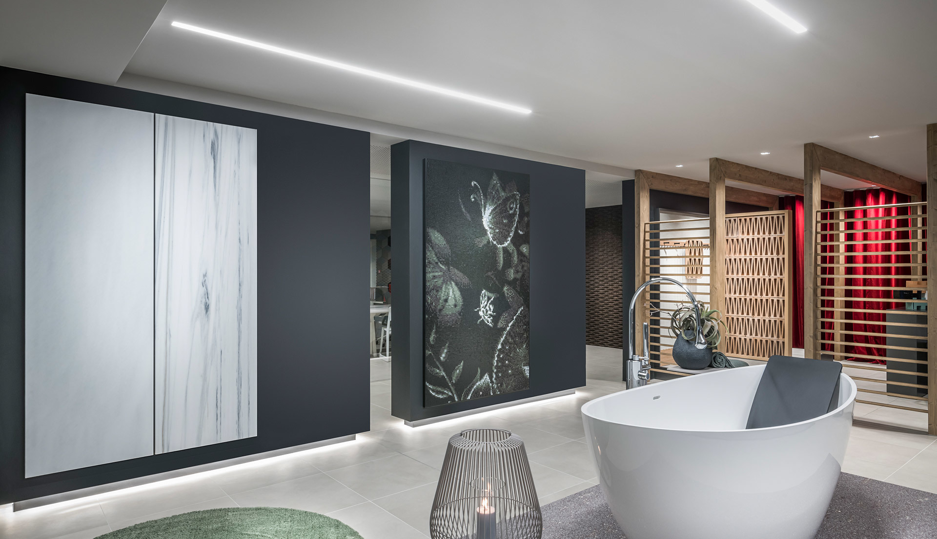 Showroom moderno con vasca freestanding bianca, luce LED lineare a soffitto, pannelli decorativi a parete e illuminazione d'accento calda.