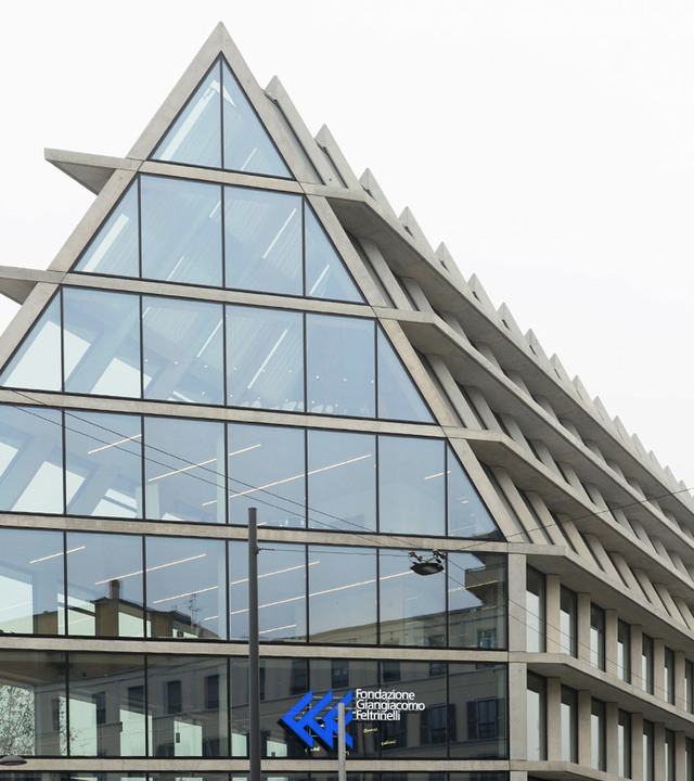 Edificio della Fondazione Giangiacomo Feltrinelli a Milano, facciata triangolare in vetro con lampade lineari LED Artemide visibili all'interno