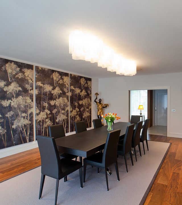Artemide rectangular ceiling lamp with cascading white diffusers illuminates an elegant dining room with dark wood table and chairs
