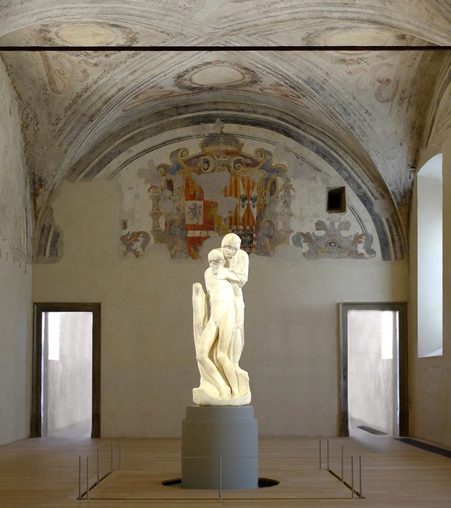 Michelangelo's Rondanini Pietà marble sculpture displayed on a pedestal in a vaulted room with Renaissance frescoes, lit by Artemide lighting