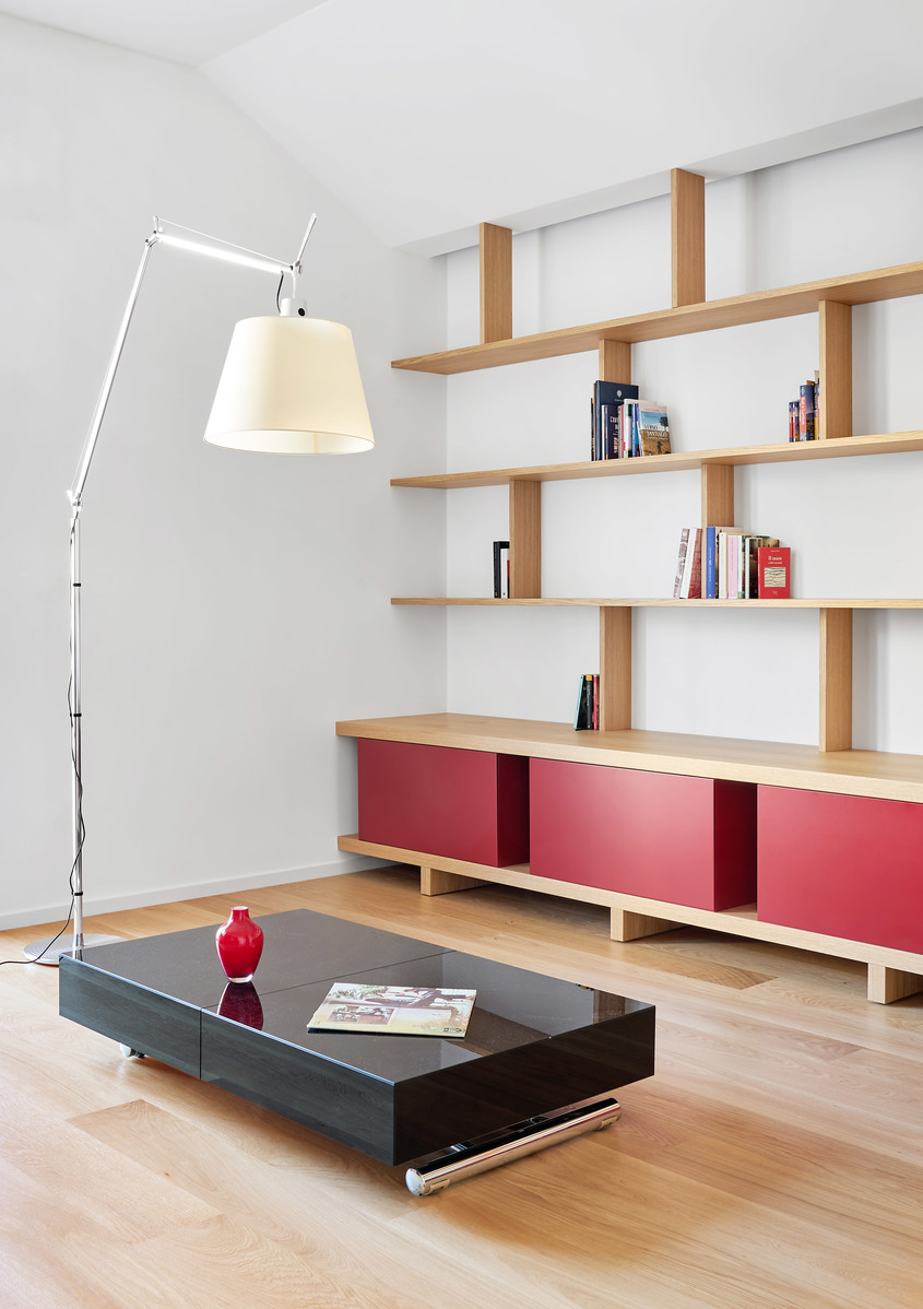Lampada da terra Artemide Tolomeo Mega con paralume bianco in soggiorno moderno con scaffali in legno e mobile rosso