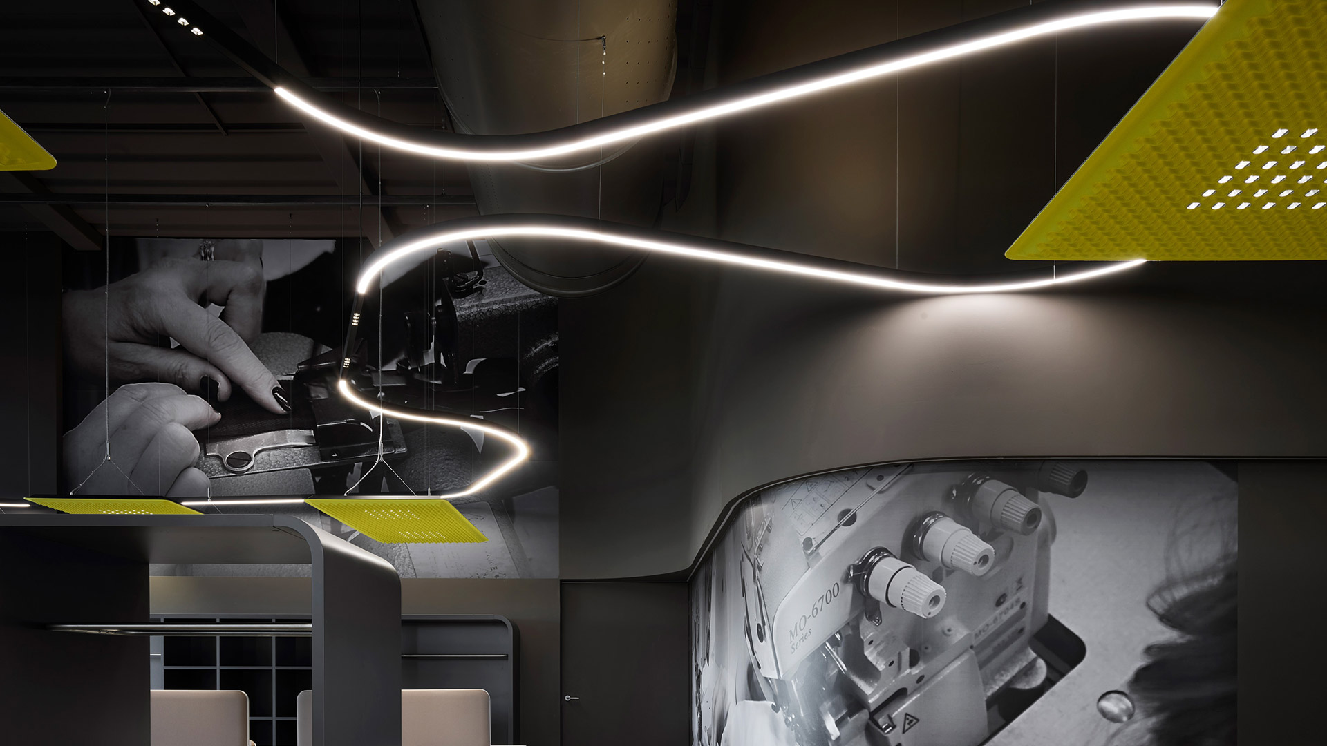 Sistema Artemide A.24: striscia LED lineare a incasso che forma una L sulla parete, abbinata a faretti su binario a soffitto in ambiente minimalista