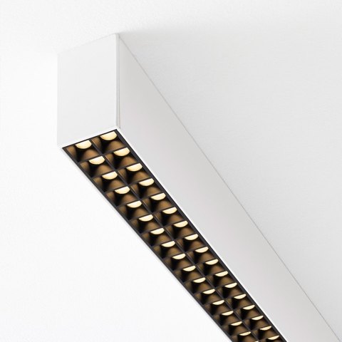 Artemide A.39 ceiling light with white housing and black microrefractive grid revealing two rows of warm LED modules