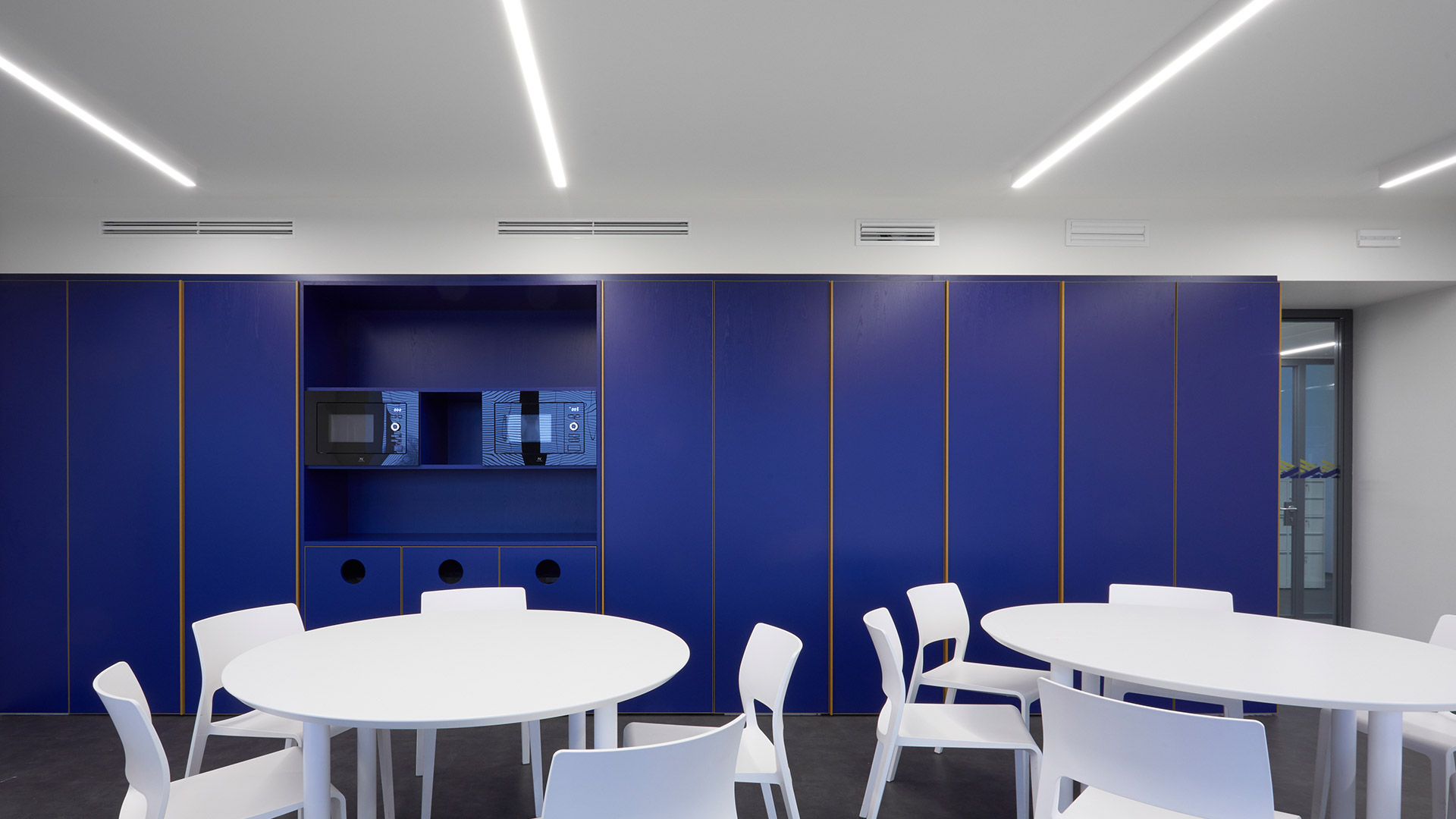 Artemide A.39: two minimalist linear LED fixtures, one ceiling-mounted and one pendant, emitting diffused white light against dark background