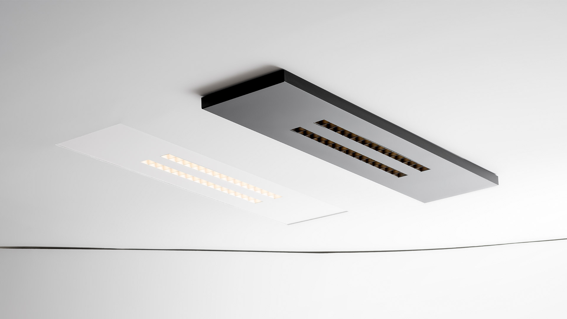 Lampada da parete Artemide A.39 Refractive Square: pannello quadrato nero con tre file verticali di lenti LED refrattive color oro caldo
