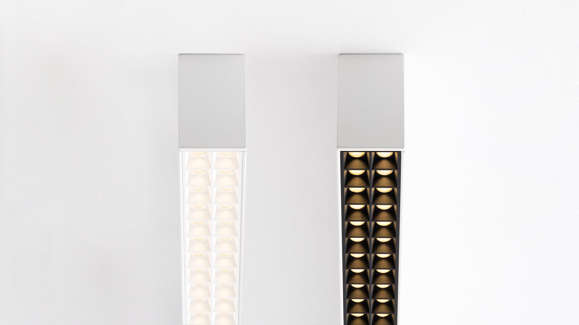 Luce da soffitto incassata Artemide A.39 con griglia nera microrifrattiva che ospita moduli LED bianco caldo in disposizione lineare