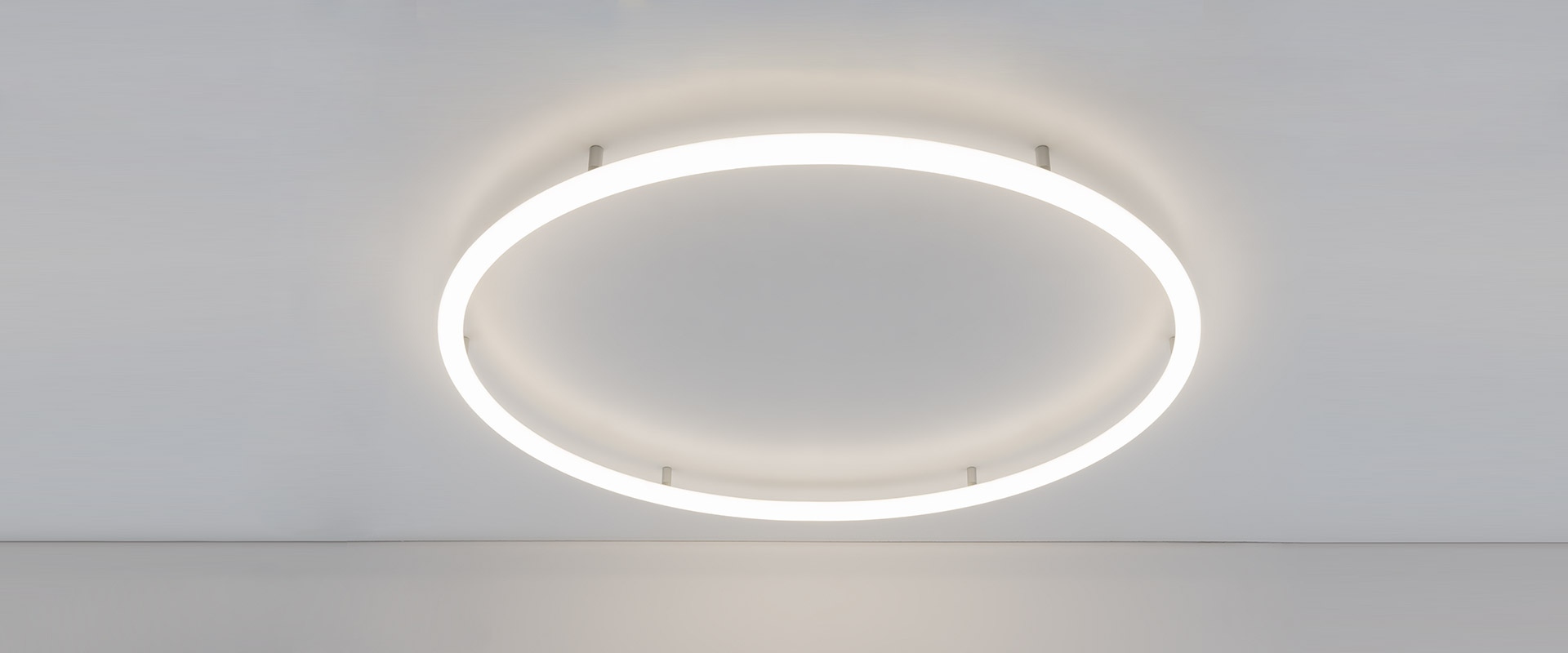 Ufficio moderno con lampade a sospensione Artemide Alphabet of Light Circular che illuminano un'area riunioni con sedie nere e tavolo bianco