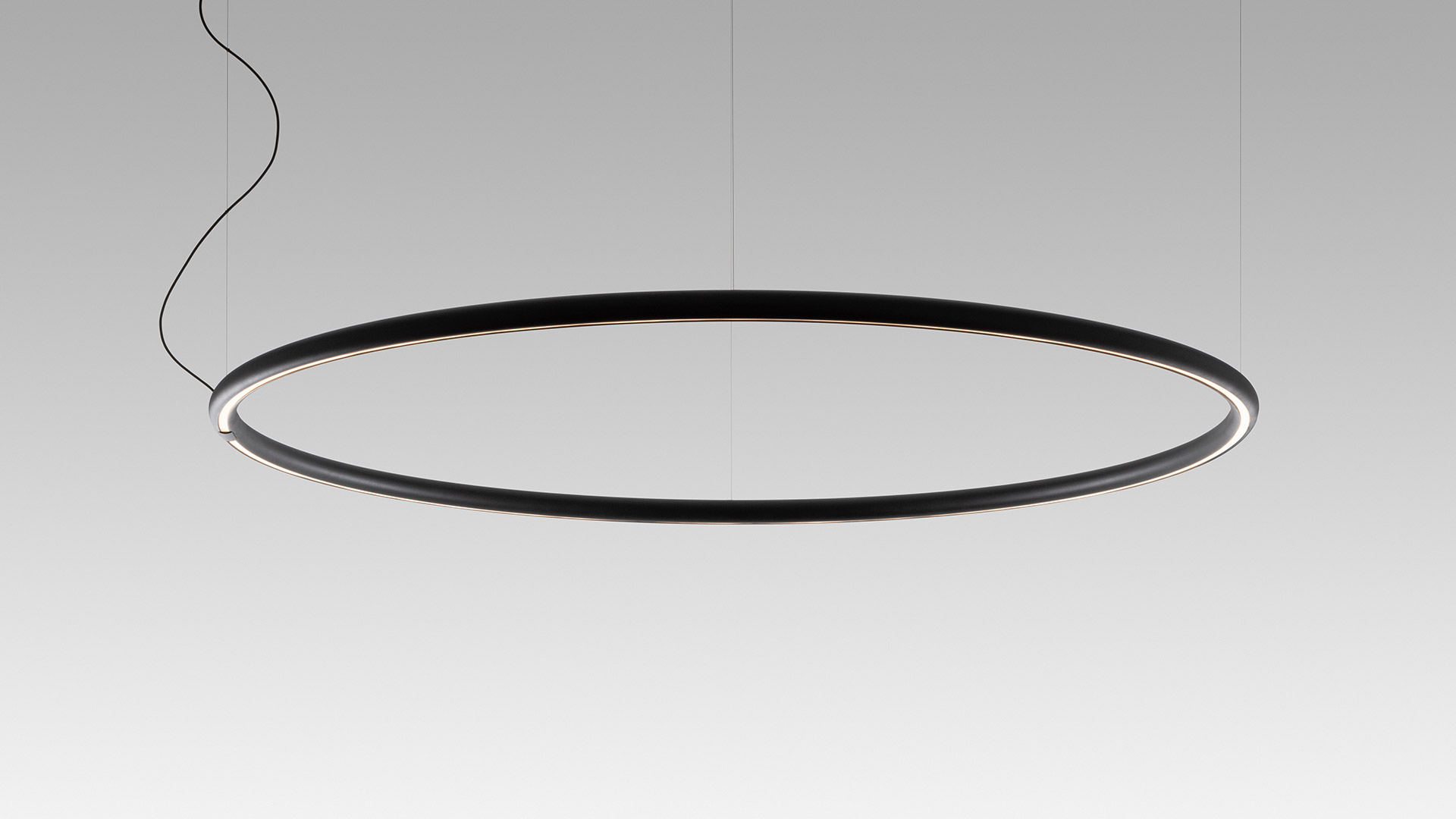 Lampada a sospensione circolare Artemide Alphabet of Light in nero opaco, grande forma ad anello con striscia LED integrata, sospesa da cavi