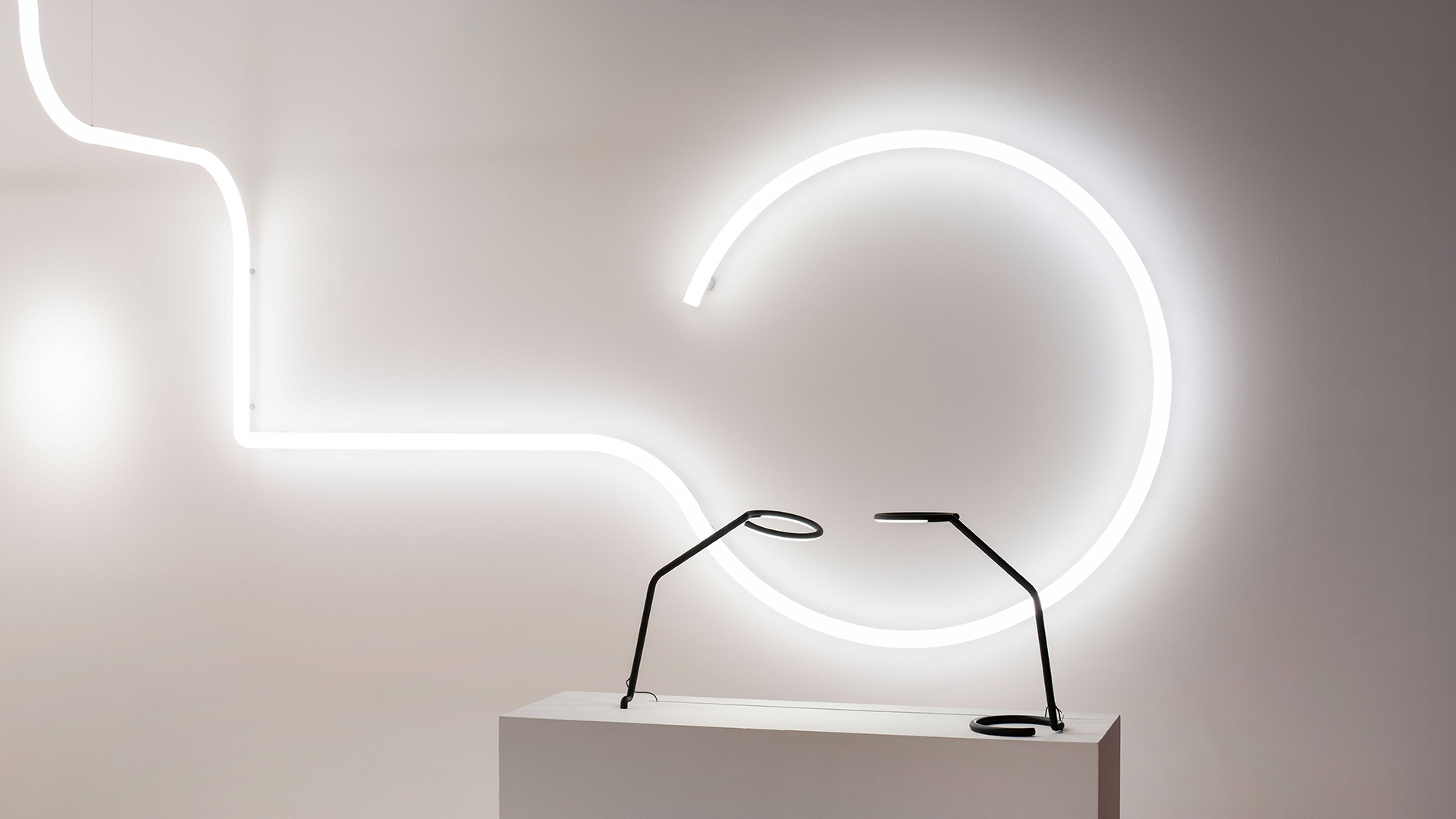 Artemide Alphabet of Light System: tubi LED lineari bianchi disposti in schema geometrico su parete illuminata di rosso intenso