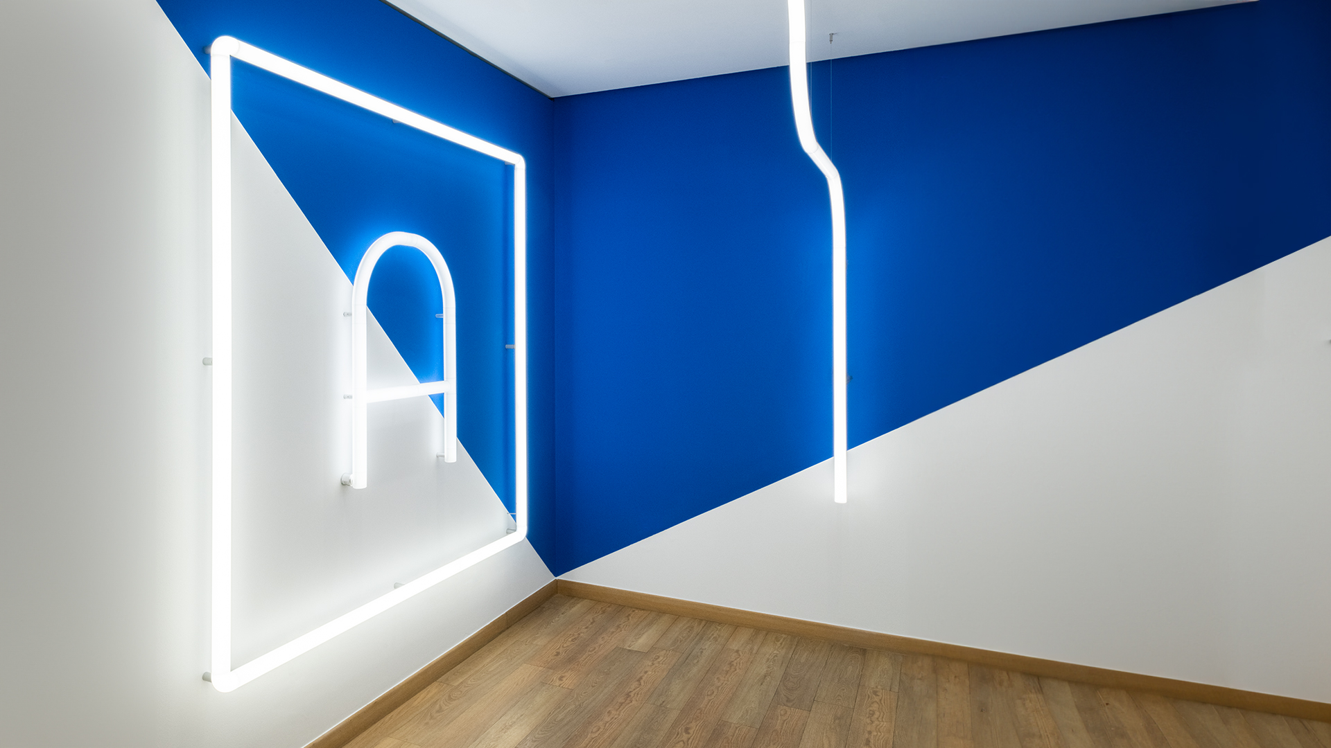 Artemide Alphabet of Light linear LED strip running along a ceiling corner, emitting warm diffused white light