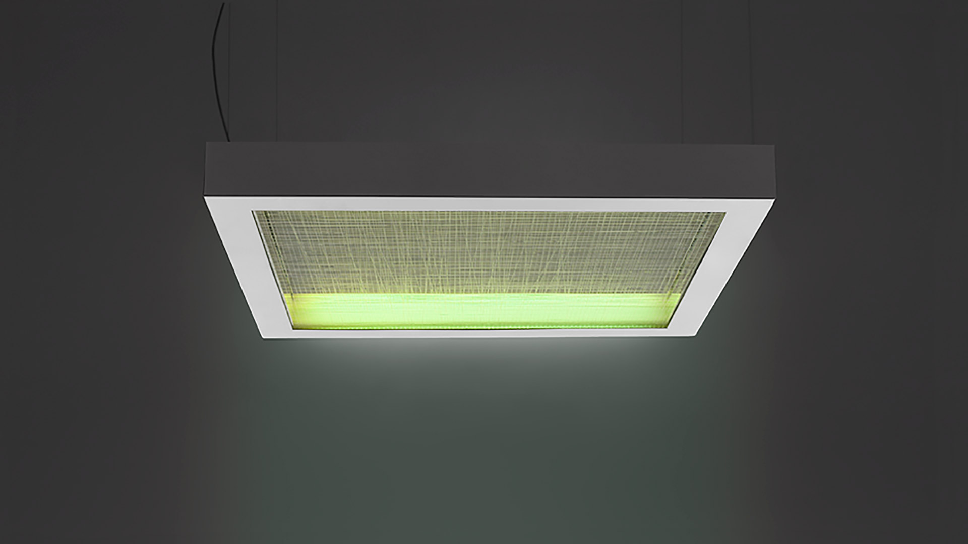 Lampada a sospensione Artemide Altrove: cornice rettangolare bianca con diffusore in tessuto illuminato di verde, sospesa dal soffitto con cavo nero