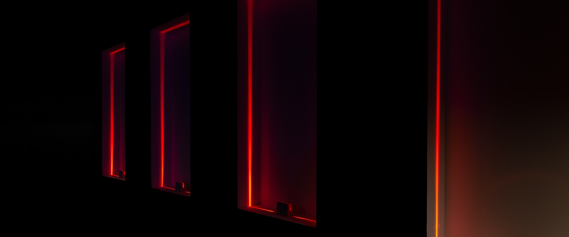 Antarktikós di Artemide: compatta luce LED da terra rettangolare bianca che emette un sottile bagliore lineare su una superficie bianca riflettente