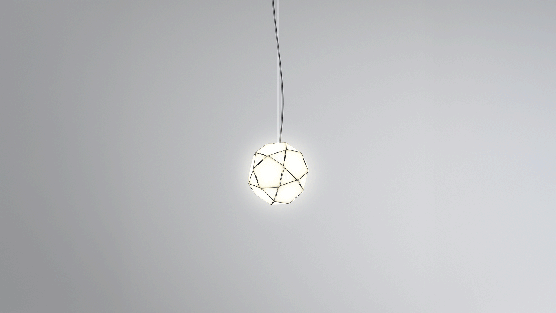 Two Artemide Arctic table lamps: left black mirrored geometric polyhedron shade, right transparent version, both with warm glowing inner sphere