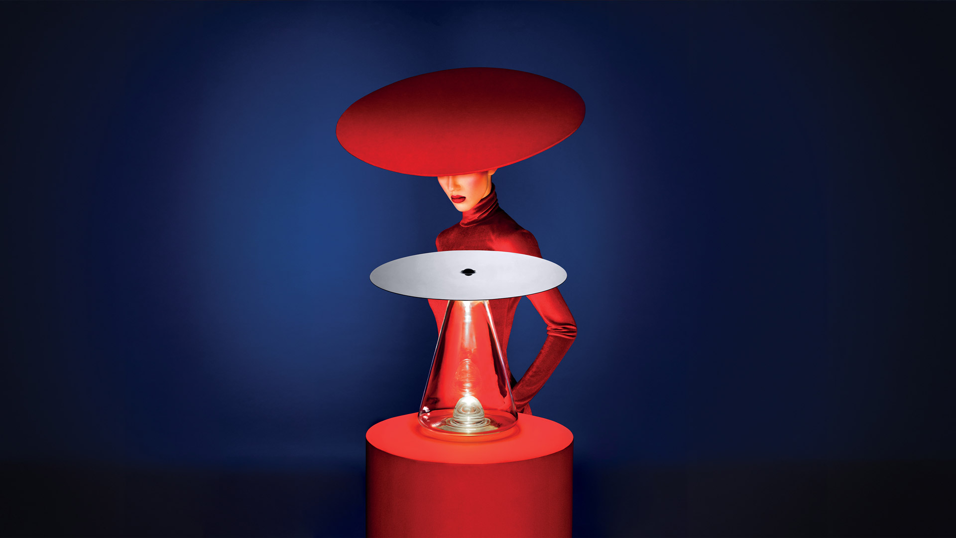 Dettaglio lampada Boltons: diffusore in vetro trasparente sormontato da una sfera cromata, con pattern di luce concentrici sul soffitto