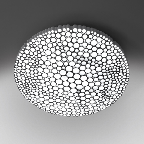 Plafoniera Artemide Calipso con diffusore rotondo caratterizzato da un motivo di aperture circolari di varie dimensioni che emettono luce bianca diffusa
