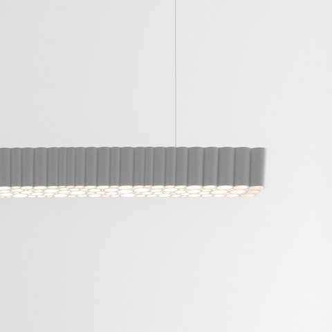 Lampada a sospensione Artemide Calipso Linear Stand Alone: corpo orizzontale allungato grigio con diffusore nervato che emette luce LED uniforme e soffusa