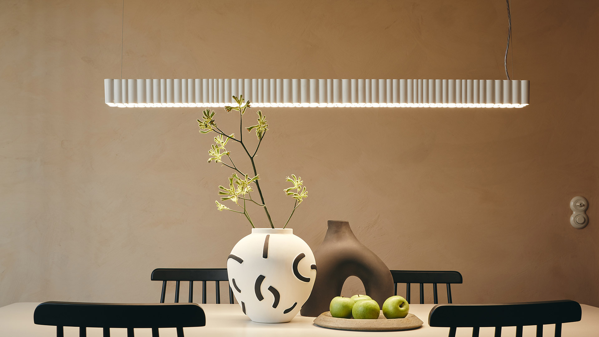 Lampada a sospensione Artemide Calipso Linear Stand Alone: elegante barra orizzontale grigia con moduli LED equidistanti che emettono luce diffusa