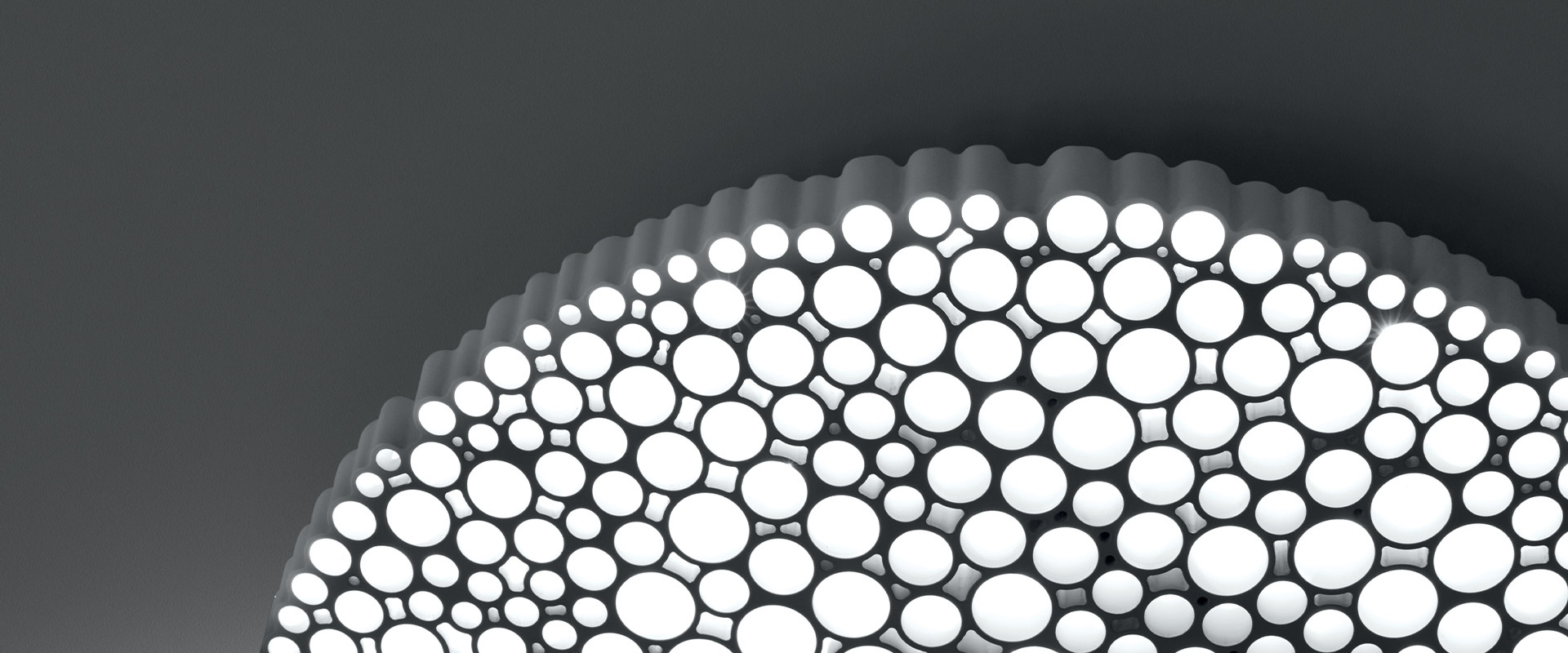Dettaglio plafoniera Artemide Calipso: diffusore circolare con cellule luminose LED di diverse dimensioni disposte a nido d'ape