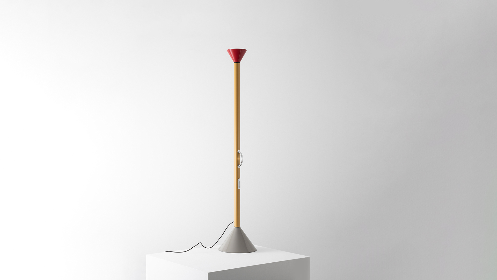 Callimaco floor lamp by Artemide: tall yellow stem, red conical shade, gray base, placed beside a white Mediterranean-style doorway