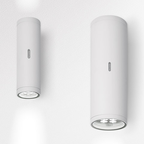 Two Artemide Calumet ceiling spotlights in white, cylindrical shape with LED light source, shown in two sizes mounted on ceiling