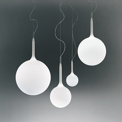Quattro lampade a sospensione Artemide Castore con sfere in vetro opalino bianco di diverse dimensioni, sospese da sottili cavi con sommità metalliche affusolate