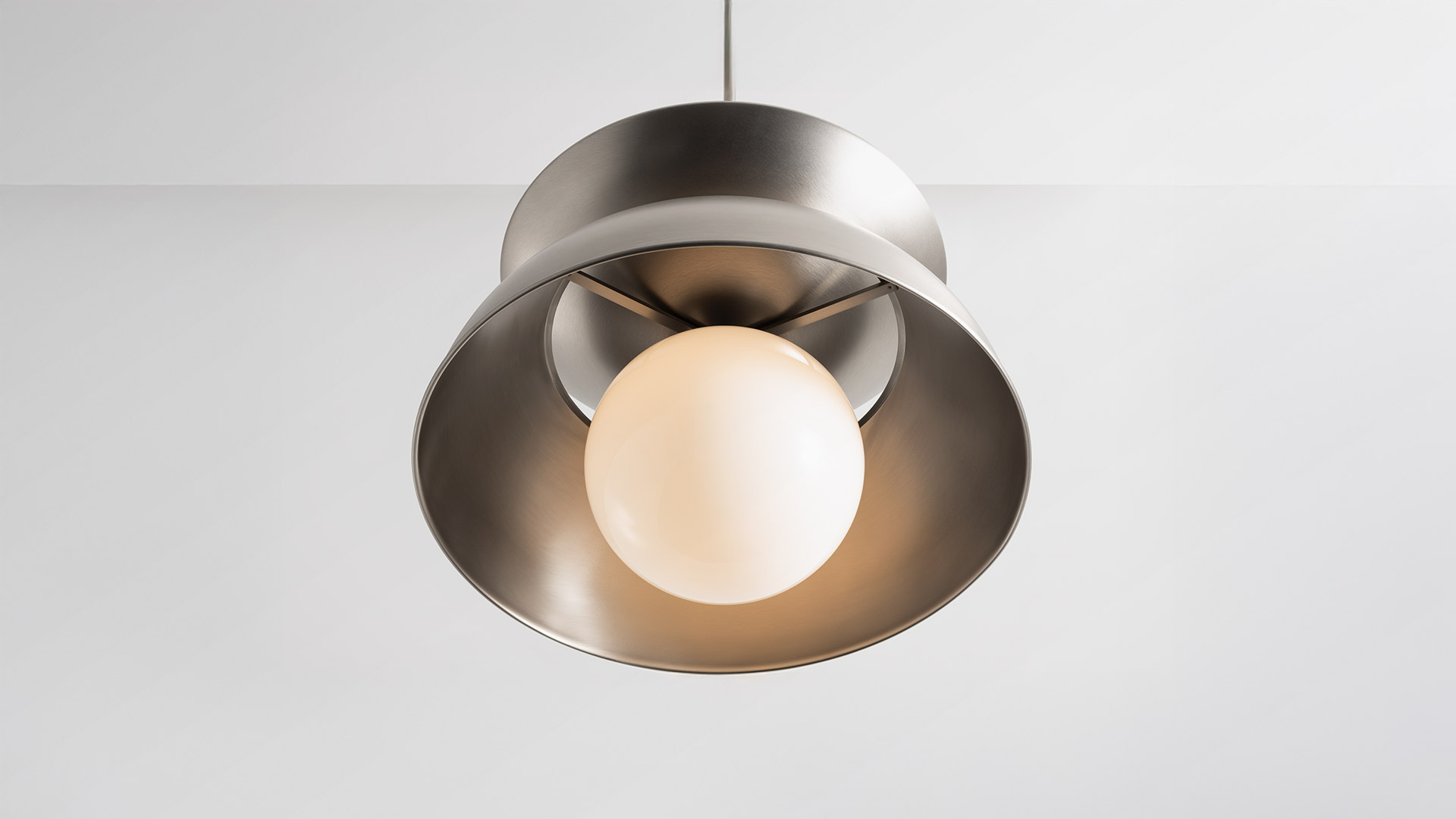 Artemide Cetra pendant lamp with brushed nickel wide-brim shade and opal white spherical glass diffuser, suspended from ceiling