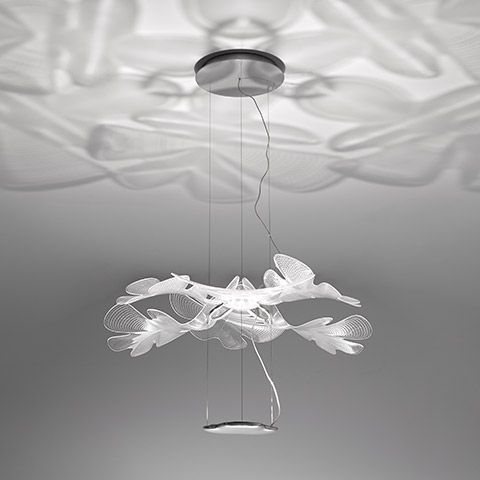 Lampada a sospensione Artemide Chlorophilia: diffusori bianchi a forma di foglia disposti a grappolo floreale, con motivi d'ombra organici sul soffitto