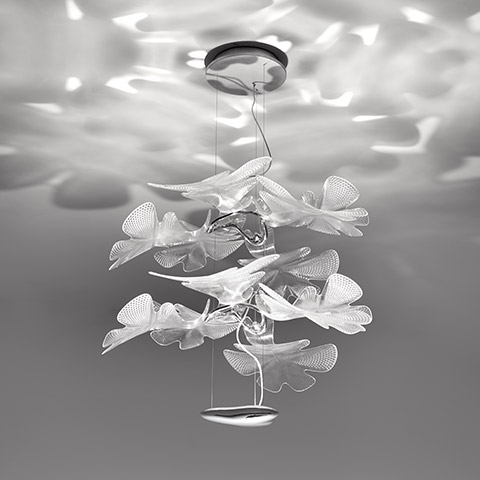 Lampada a sospensione Artemide Chlorophilia 2 con diffusori traslucidi a forma di foglia sovrapposti che proiettano pattern luminosi organici sul soffitto