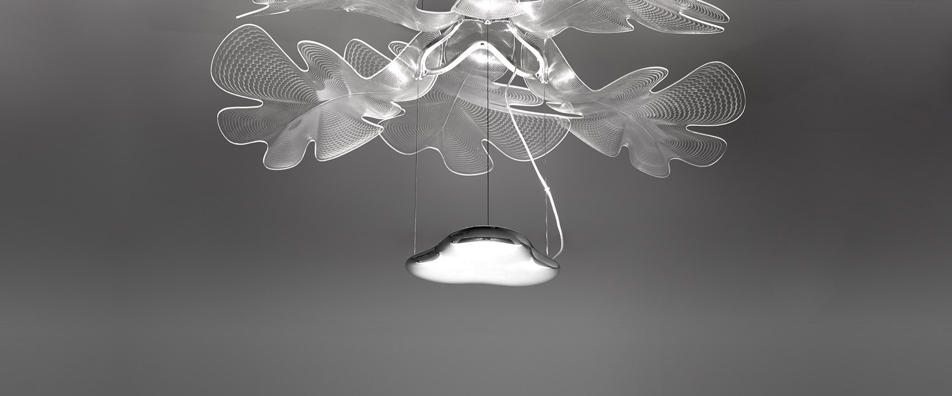 Artemide Chlorophilia ceiling lamp: organic leaf-shaped transparent diffuser mounted on ceiling with pendant light source below