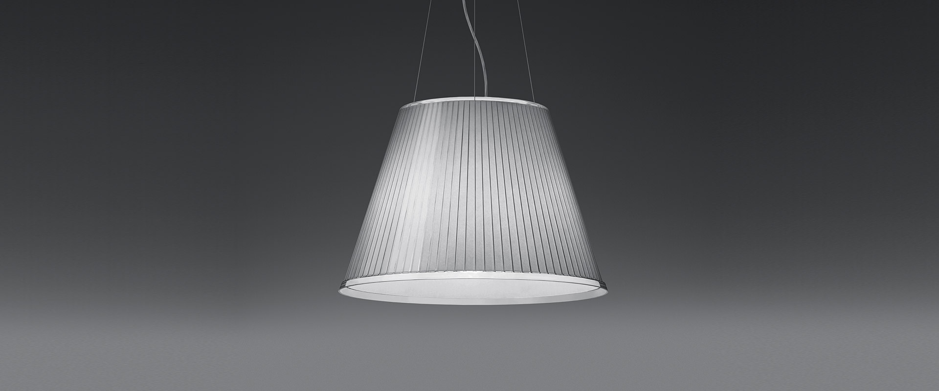 Due lampade da terra Artemide Choose su stelo cromato: sinistra con paralume conico bianco verticale, destra con paralume beige inclinato