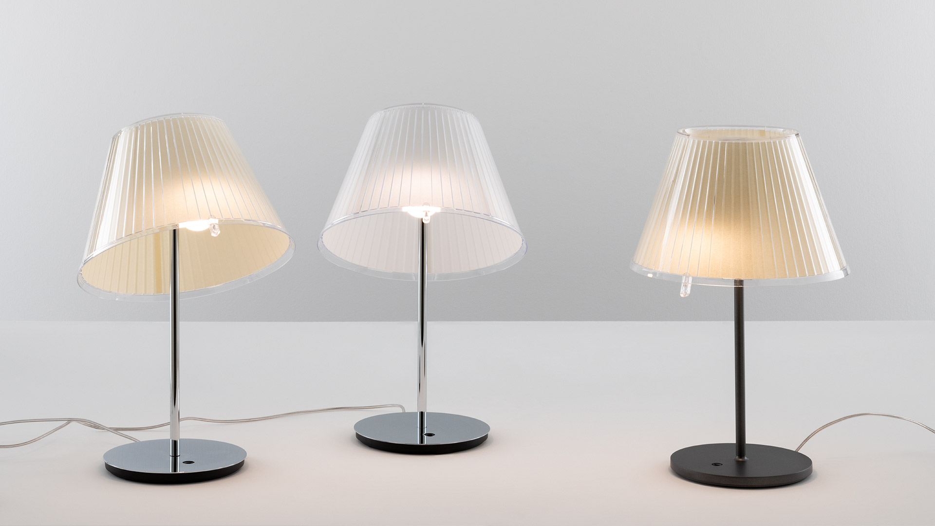 Due lampade a sospensione Artemide Choose: sinistra paralume plissettato argento, destra paralume plissettato beige caldo, entrambe coniche