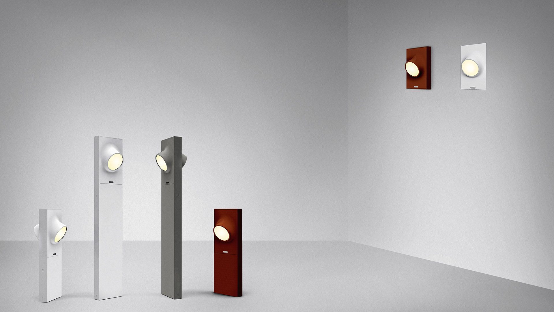 Lampade da terra e da parete Artemide Ciclope in bianco, grigio e rosso scuro, con lente LED circolare, nelle versioni a piantana e da parete.