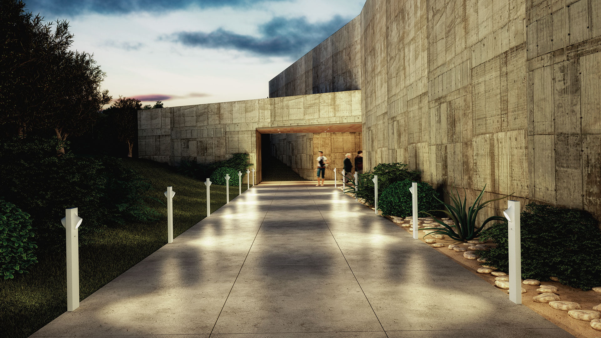Vialetto esterno al crepuscolo fiancheggiato da luci paletto Artemide Ciclope, che conduce all'ingresso di un edificio brutalista in cemento.