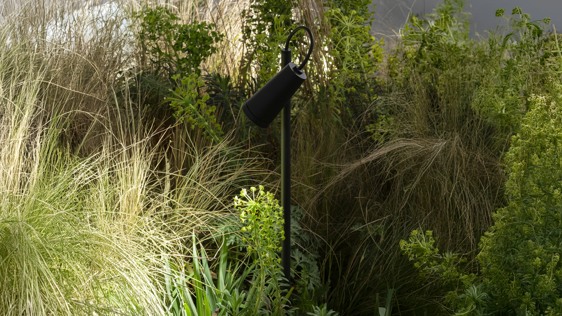 Tre lampade Artemide Conus in rosso, grigio scuro e verde, con teste orientabili su versioni a stelo da terra e con cavo a spina