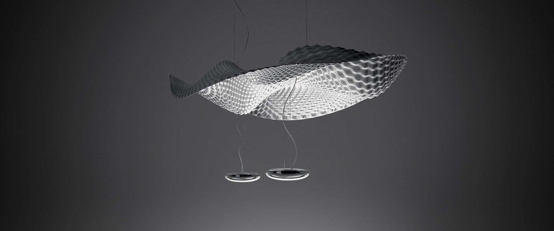 Lounge ufficio moderno con lampade a sospensione Artemide Cosmic Angel con diffusori a rete decorativi, che illuminano aree salotto con tavoli rotondi