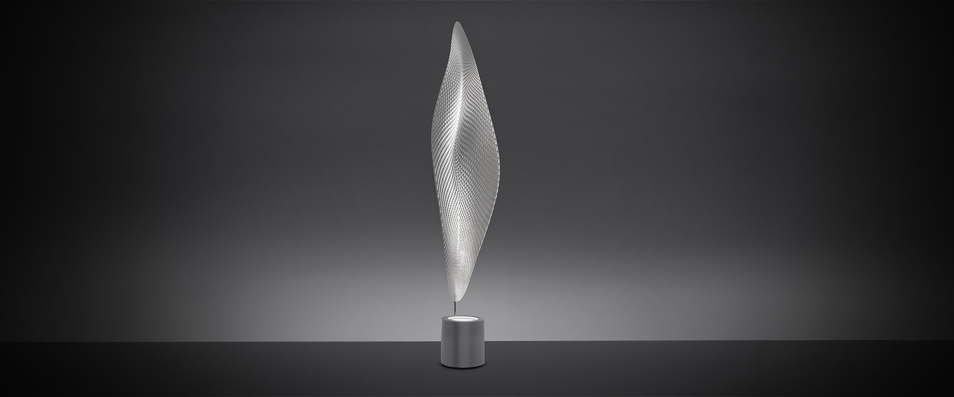 Lampada da terra Artemide Cosmic Leaf: alto diffusore scultoreo a forma di foglia in rete trasparente su base cilindrica metallica