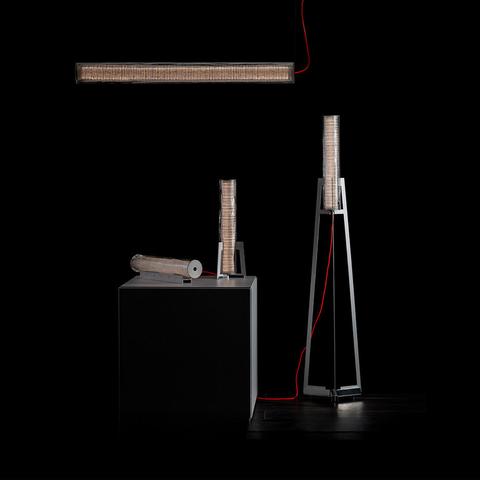 Collezione Artemide Criosfera: lampada a sospensione orizzontale, da tavolo e da terra con paralumi cilindrici texturizzati e cavi rossi su sfondo scuro
