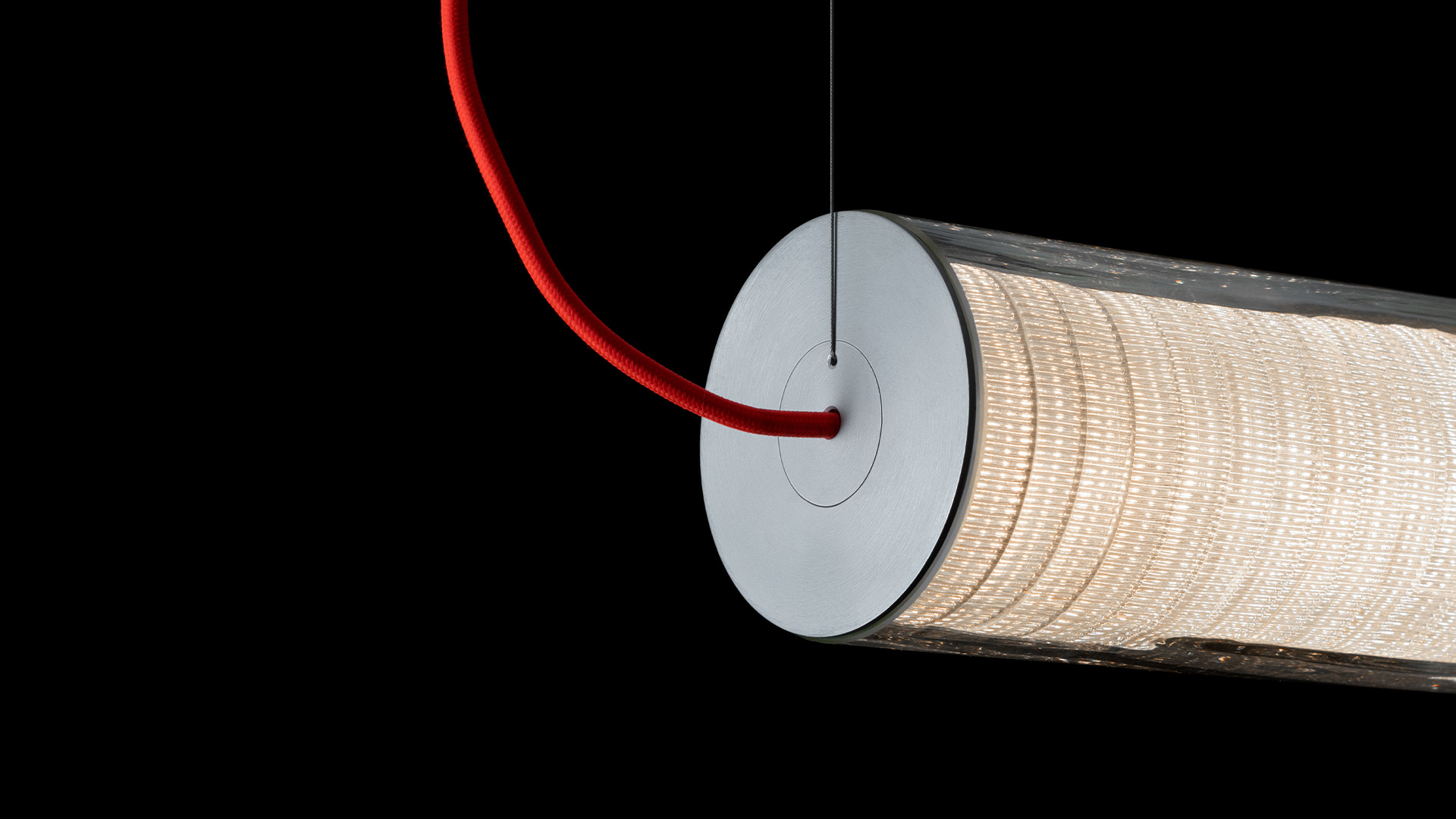 Artemide Criosfera: cylindrical pendant lamp with white coiled diffuser and orange cord, alongside a matching table version on a white surface